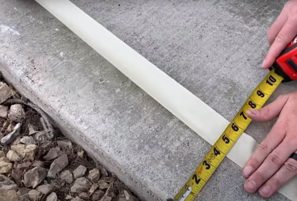 man measuring the driveway