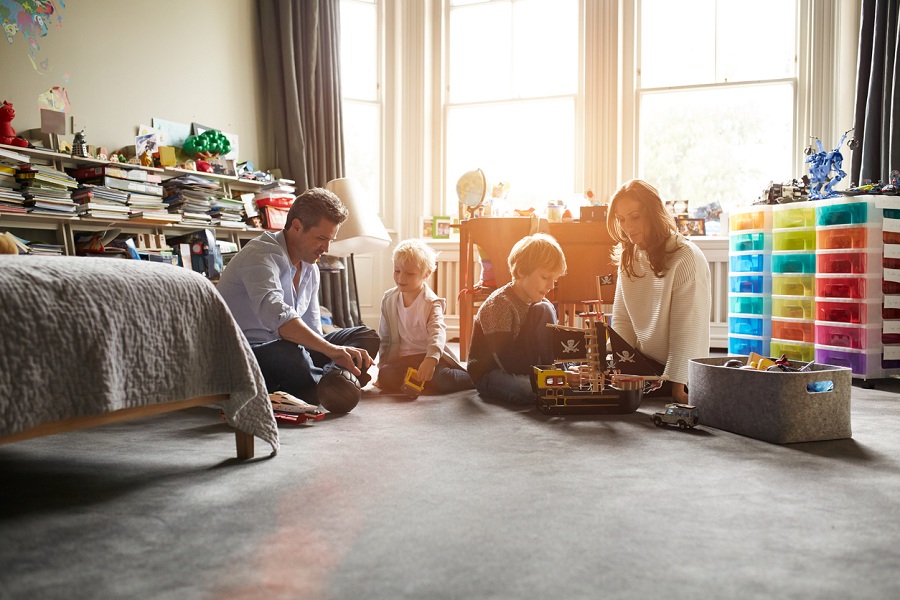 Parents playing with their 2 children while sitting on the floor