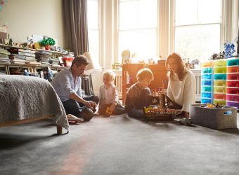 Parents playing with their 2 children while sitting on the floor