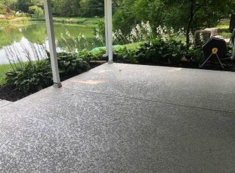 House overlooking a lake with a spray knockdown texture finish flooring in a front patio