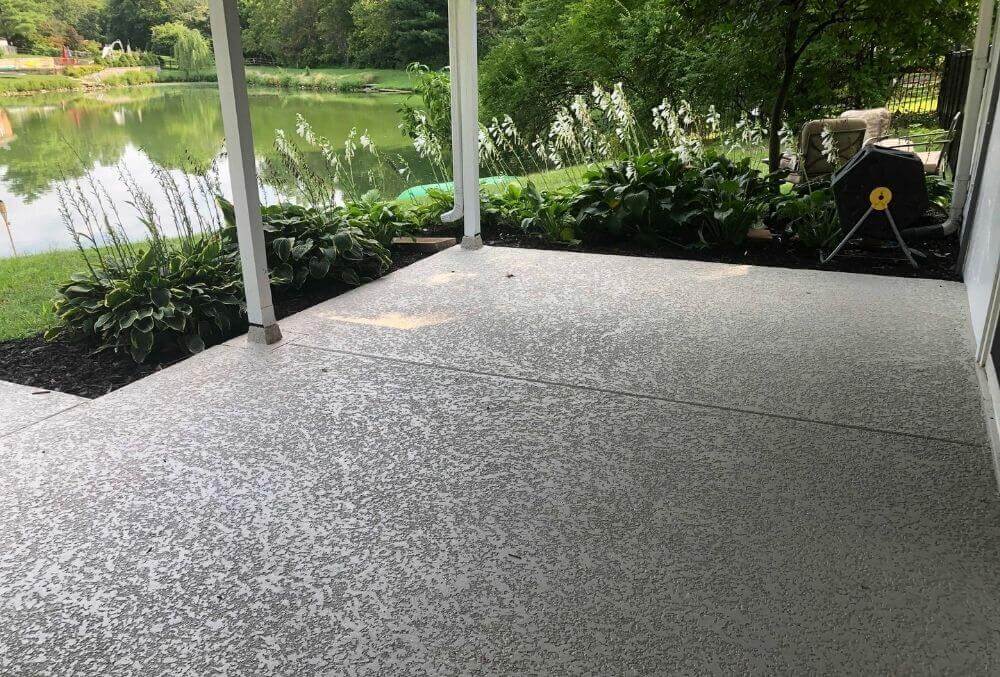 House overlooking a lake with a spray knockdown texture finish flooring in a front patio