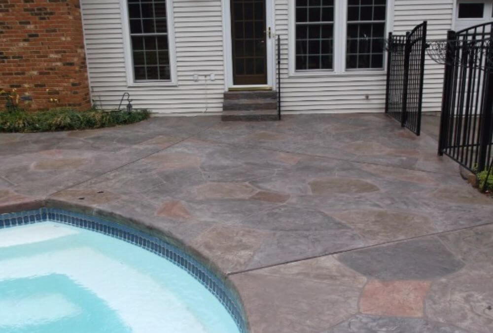 Stamped concrete pool deck with decorative pattern and textured finish.